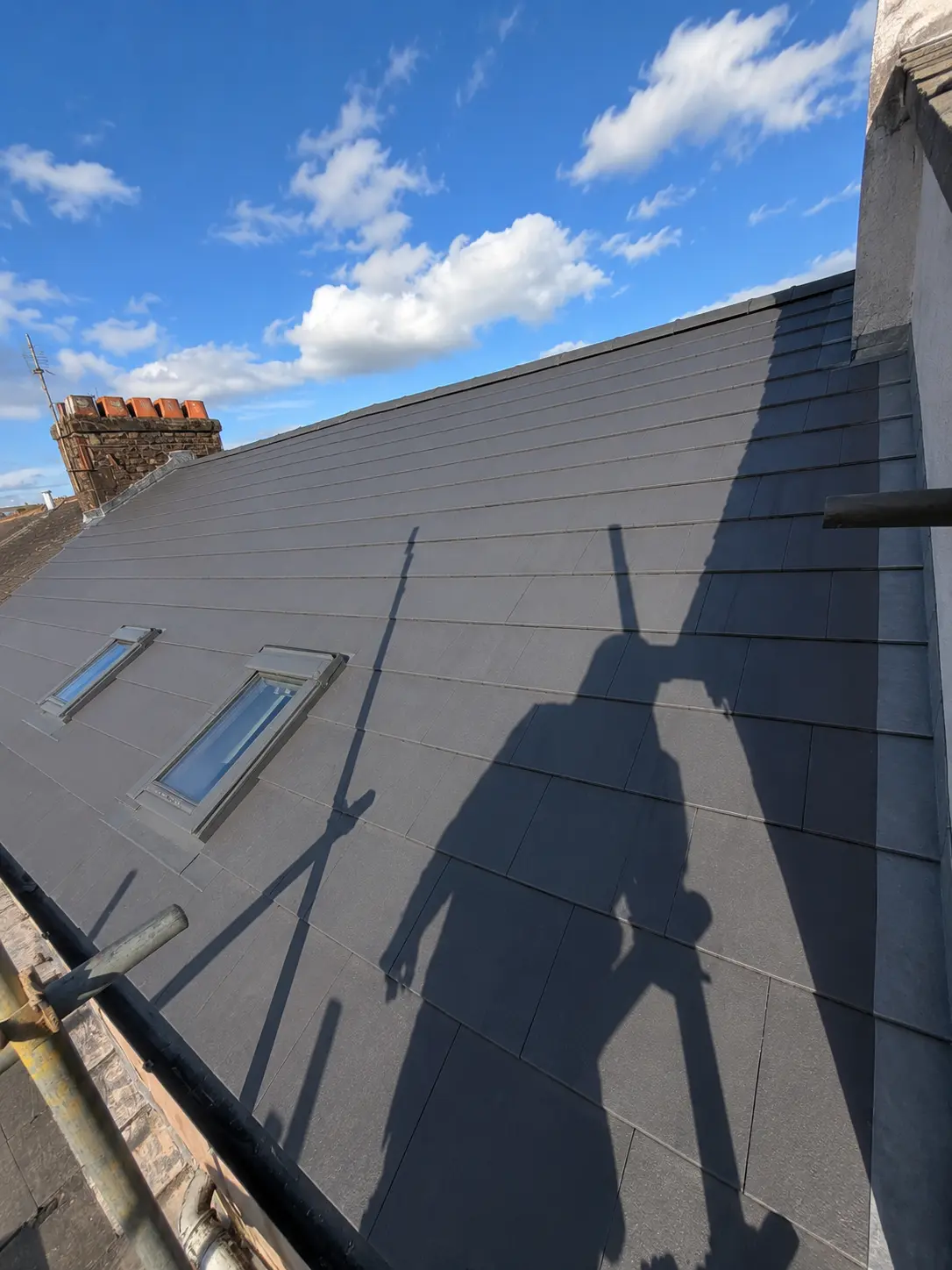 Roofers working on a slate pitched roof with scaffolding in place